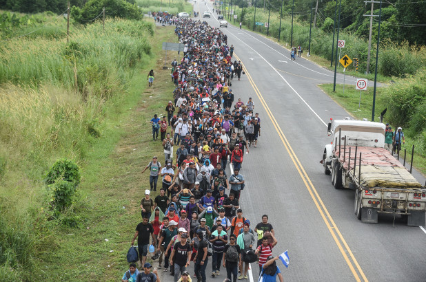 Caravan migrants reach Tijuana, start climbing the border fence